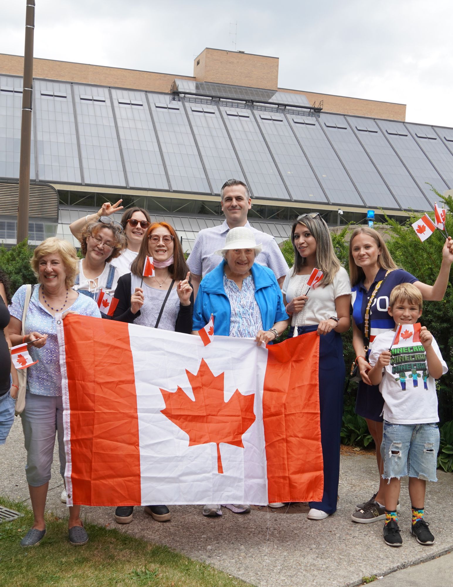 A group of people holding a Canadian Flag.