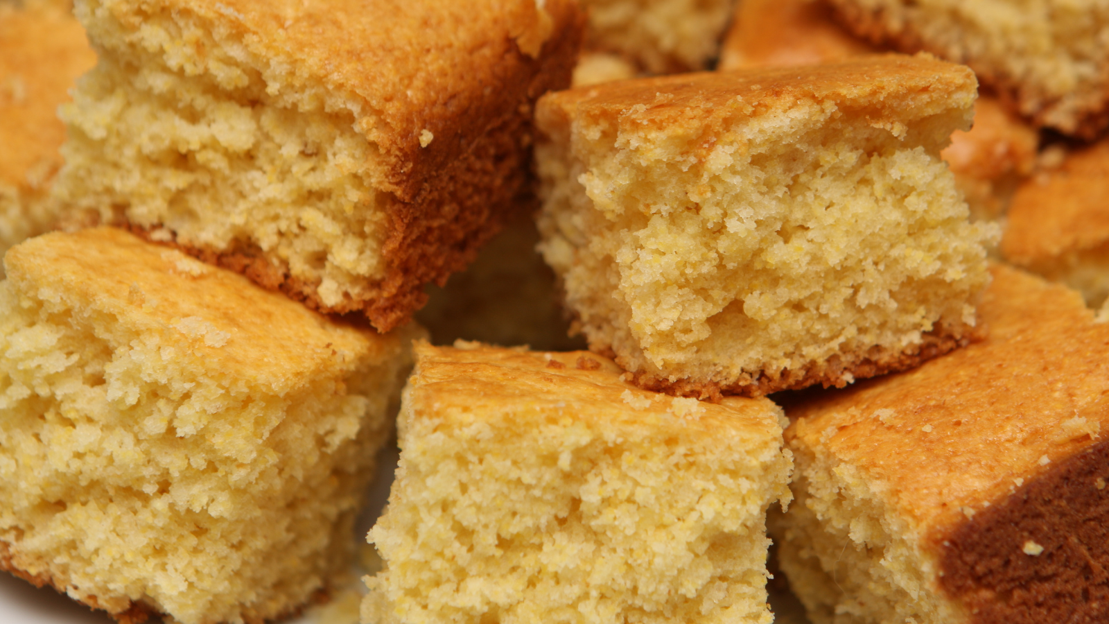 Close up of a pile of square shaped corn bread.