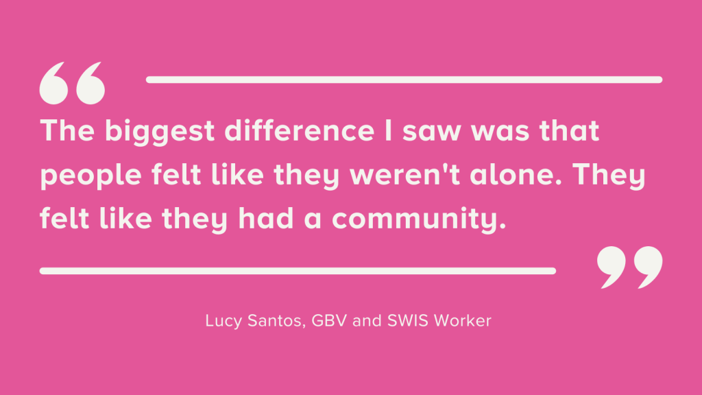 White text bordered with quotation marks on a pink background. The text reads, "The biggest difference I saw was that people felt like they weren't alone. They felt like they had a community." Lucy Santos, GBV and SWIS Worker, said this.