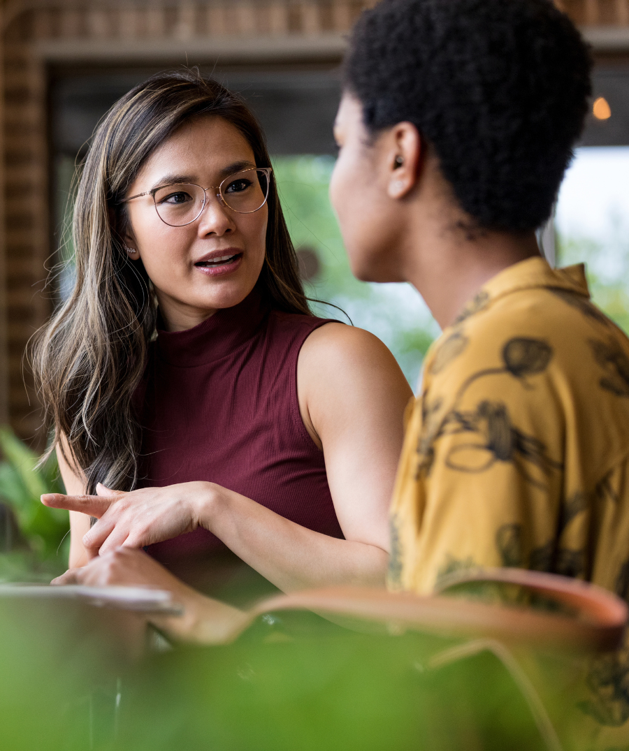 Two people sitting at a table and having a conversation.