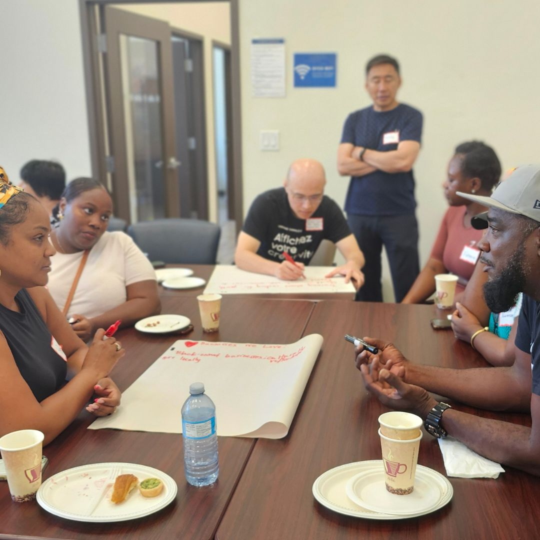 a group of people sitting around a table brainstorming their ideas on chart paper