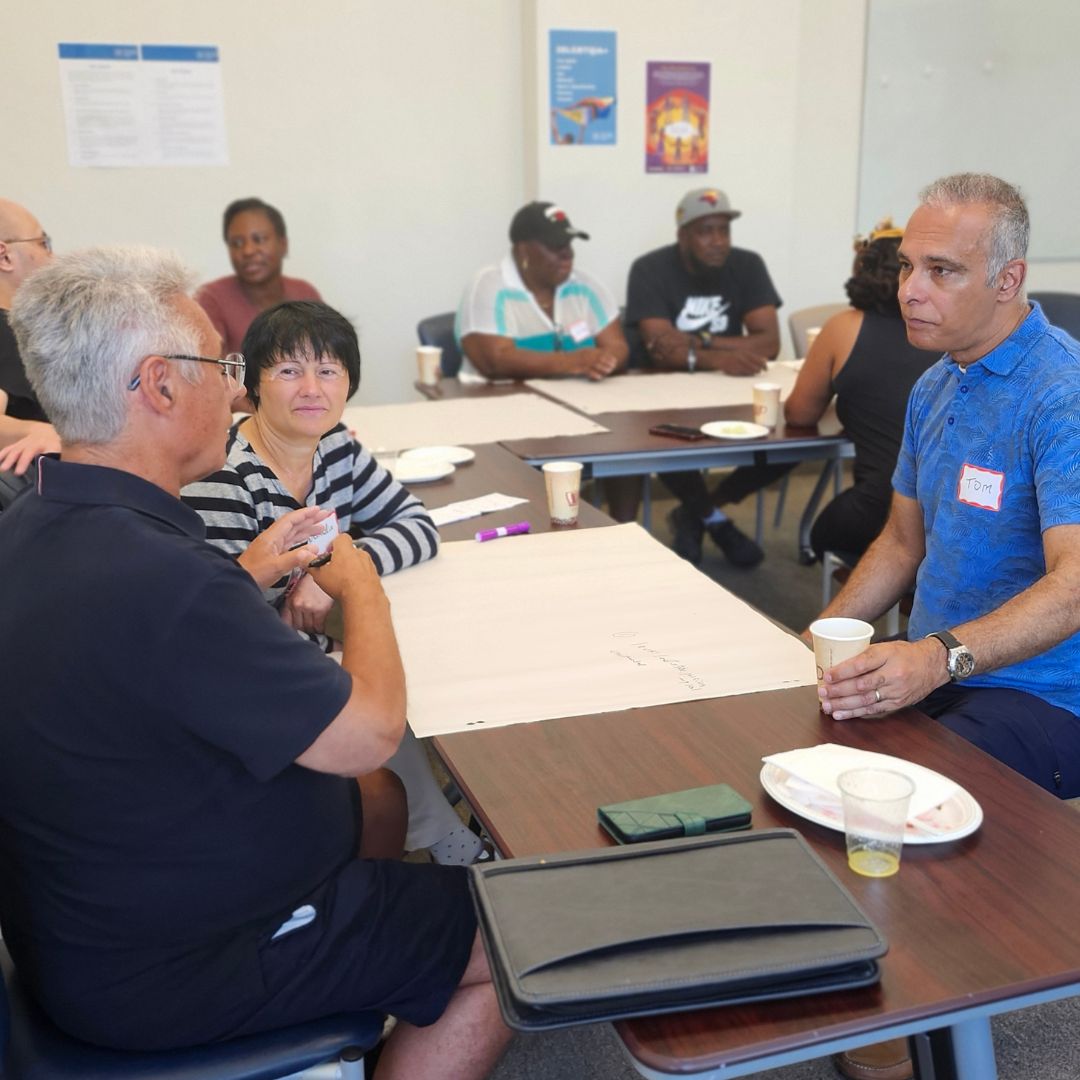 a group of people sitting at tables discussing ideas