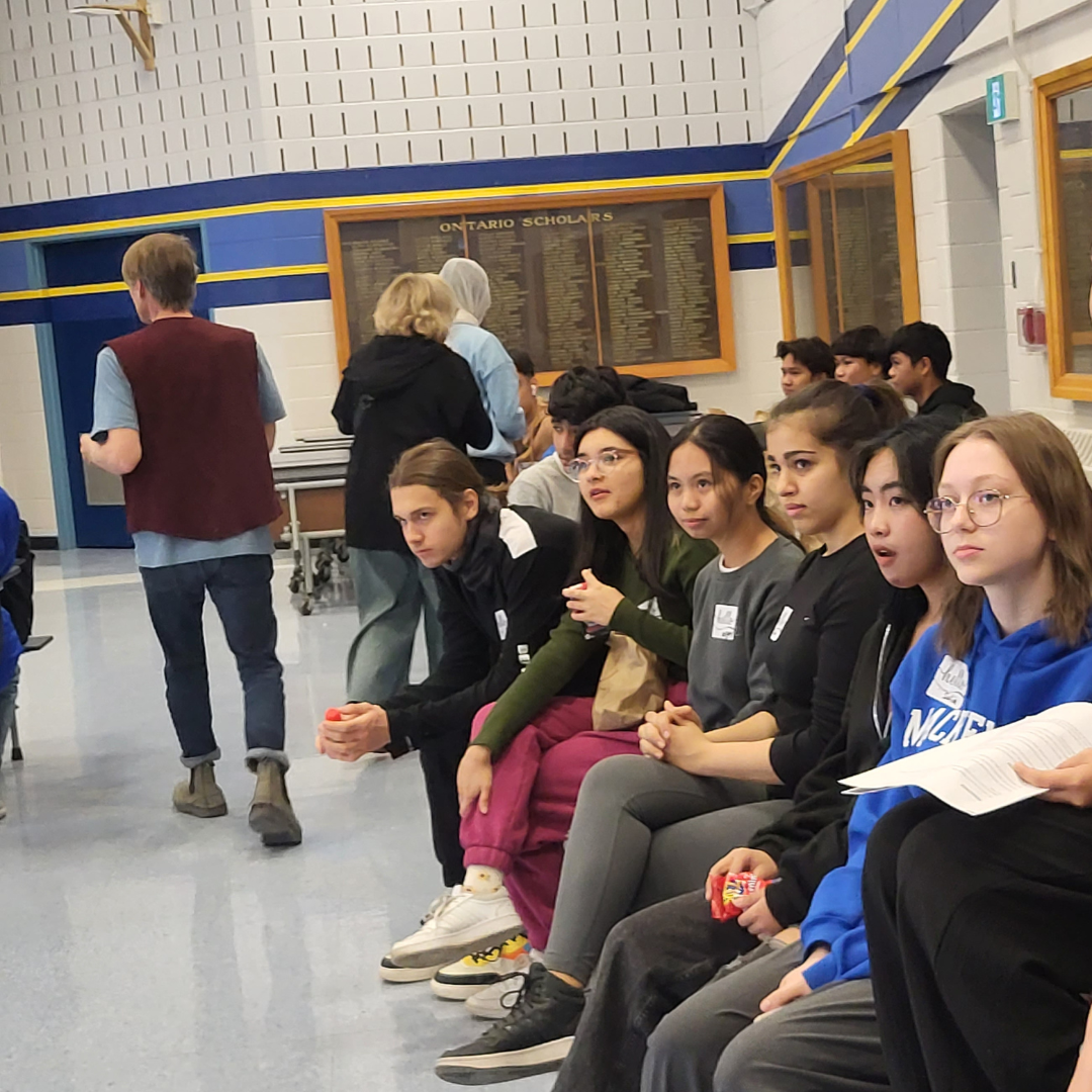 A group of youth sitting in a school auditorium