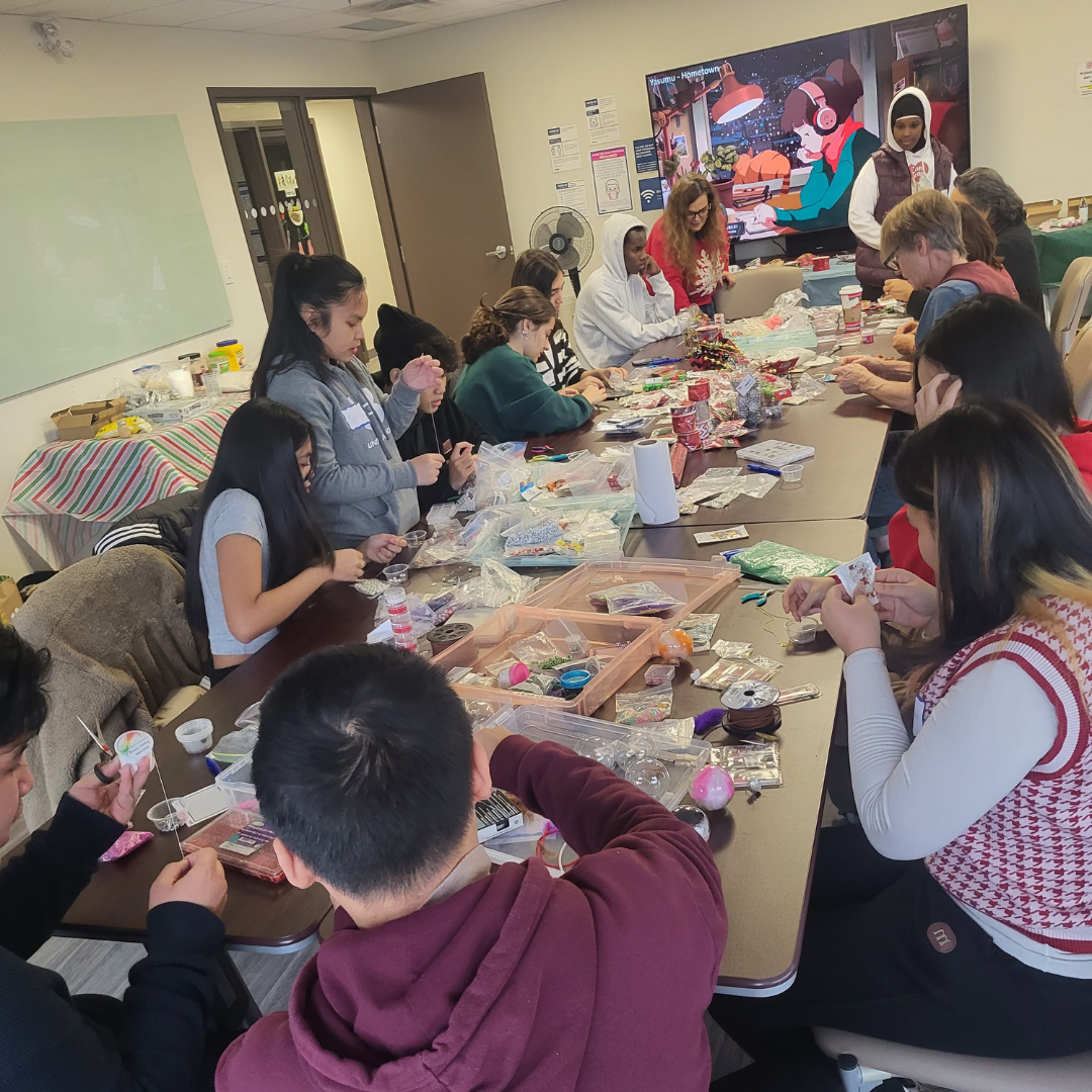 Youth at a table makinhg bracelets