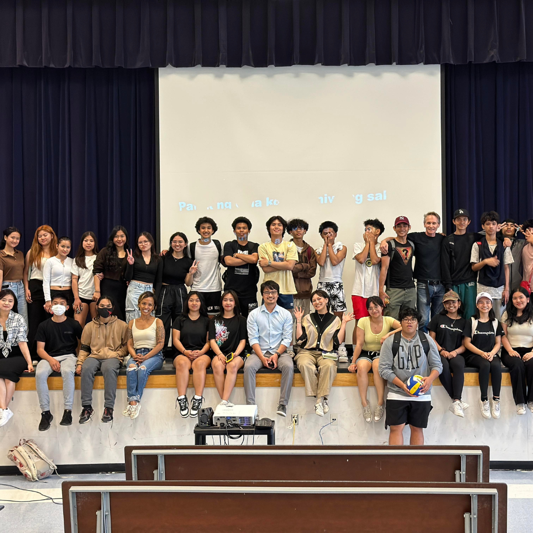 a group of people posing for a photo in front of a stage