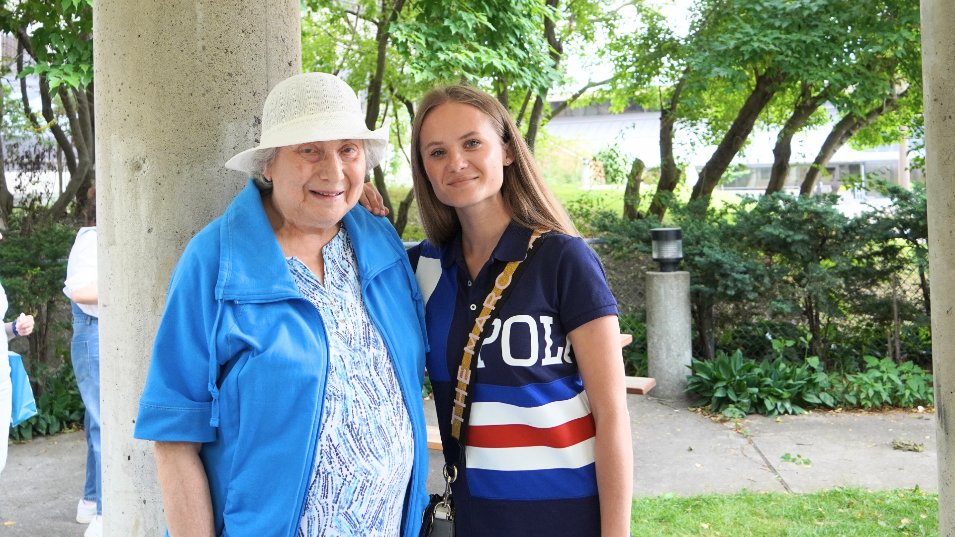 Two Women smiling at the camera. They are in a park.