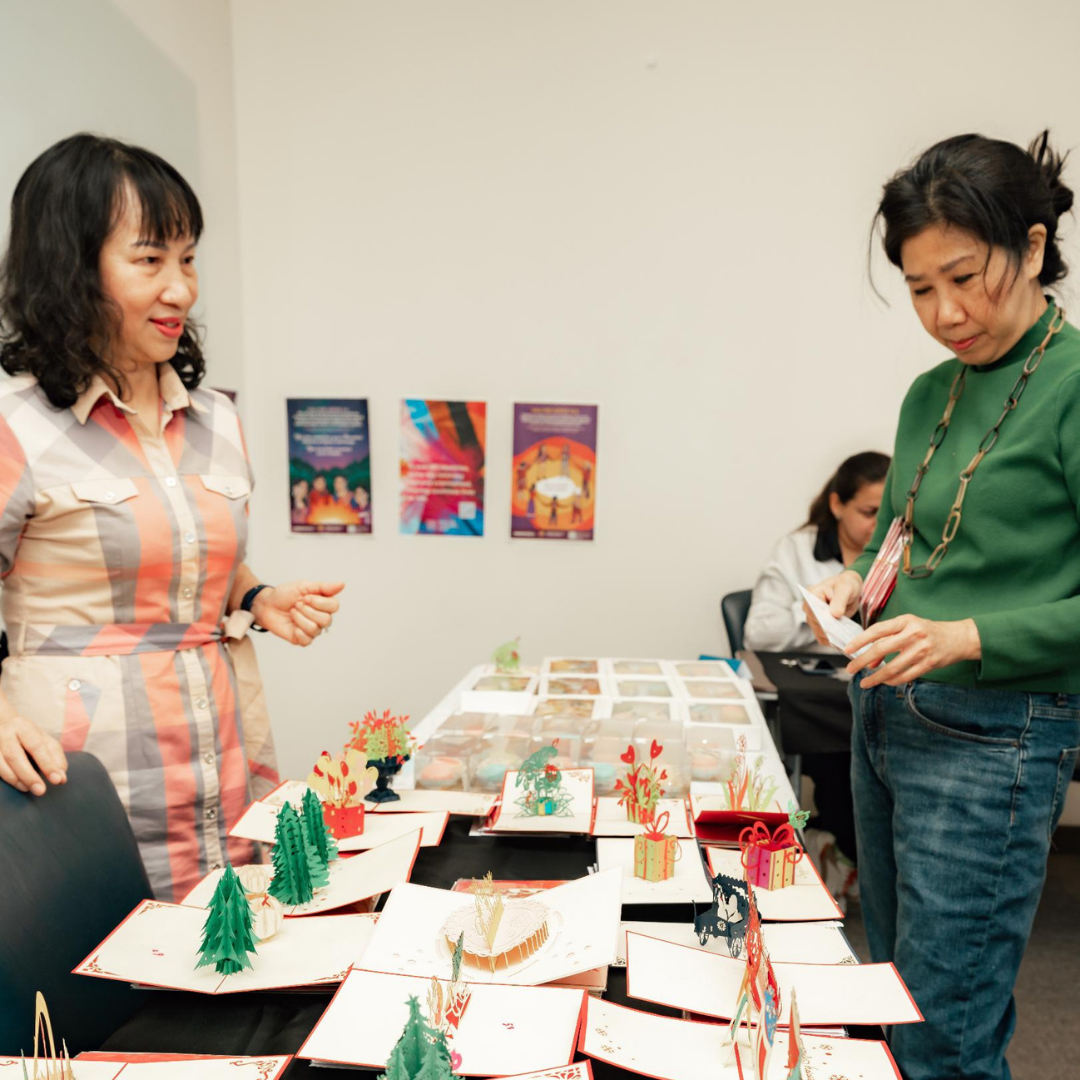Two women beside a table with pop up cards.