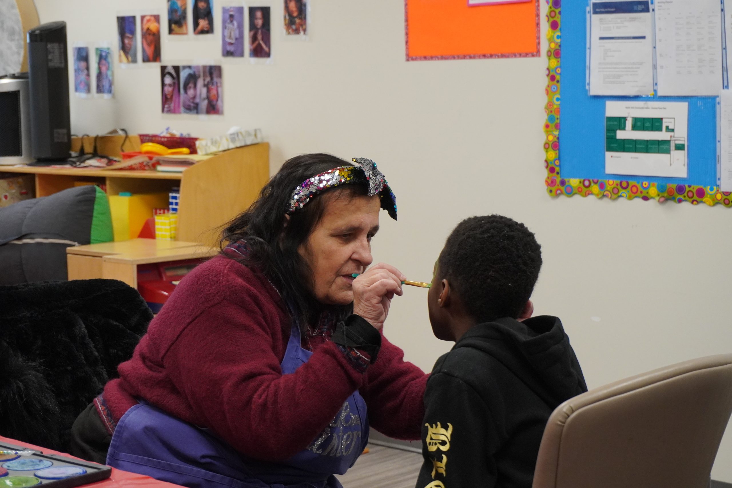 Isabel painting a child's face.