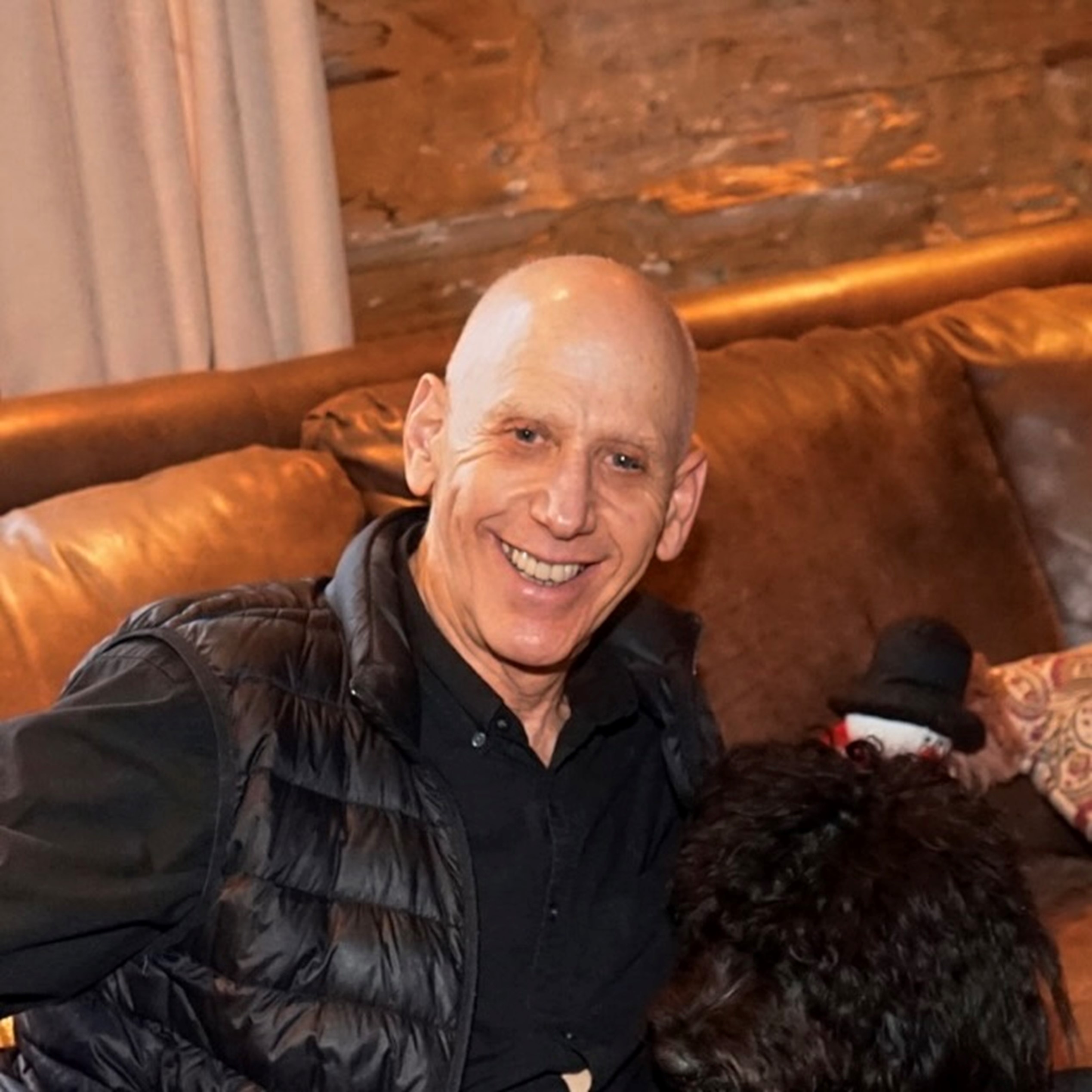 A picture of Mike sitting and smiling.