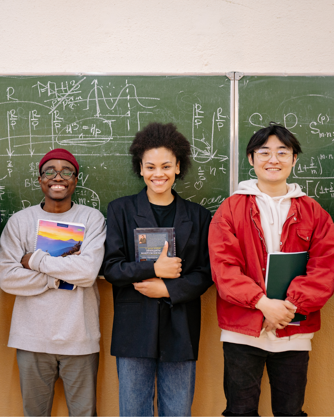 Three people standing in front of a chalkboard with mathematical equations.